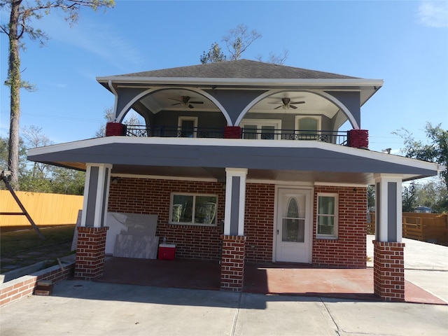 view of front facade with ceiling fan and a balcony