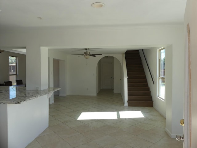 unfurnished living room featuring light tile patterned floors and ceiling fan