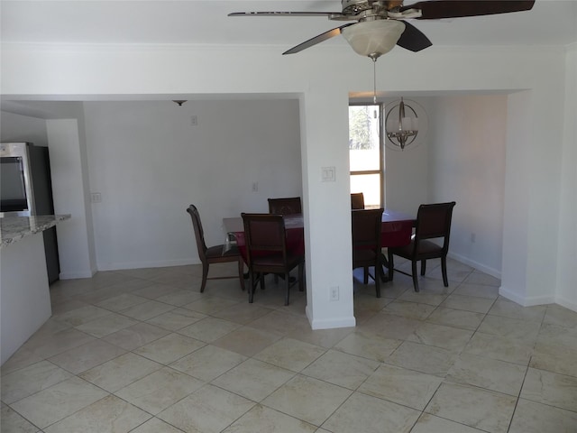 dining room featuring ceiling fan with notable chandelier and light tile patterned flooring