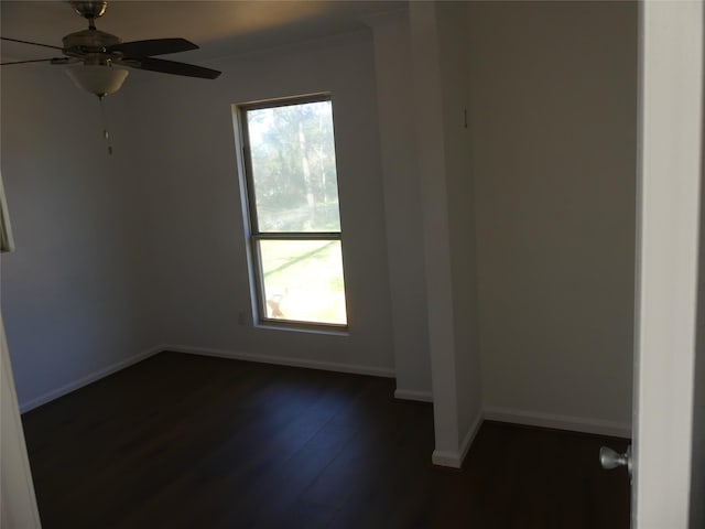 empty room with plenty of natural light, ceiling fan, and dark wood-type flooring