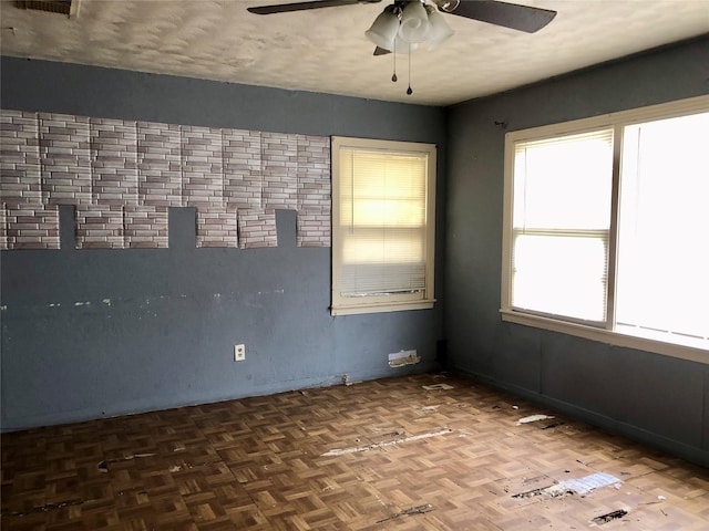 empty room featuring ceiling fan and parquet flooring