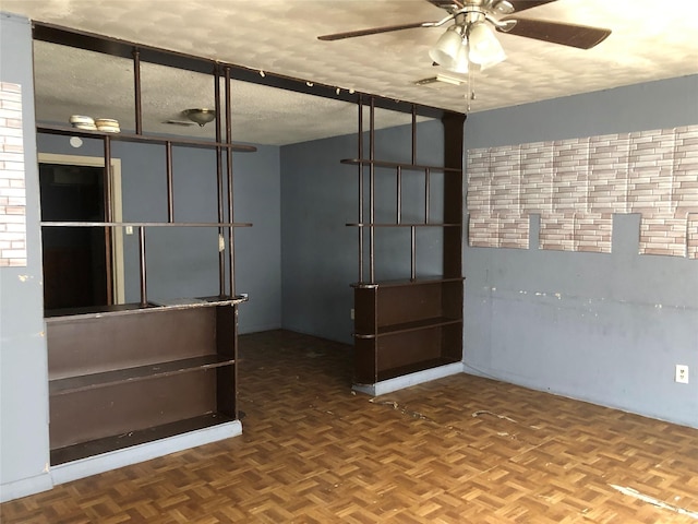 empty room with a textured ceiling, parquet floors, and ceiling fan