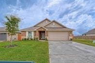 single story home with a garage and a front lawn