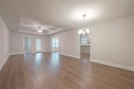 interior space with dark hardwood / wood-style floors, a chandelier, and a tray ceiling