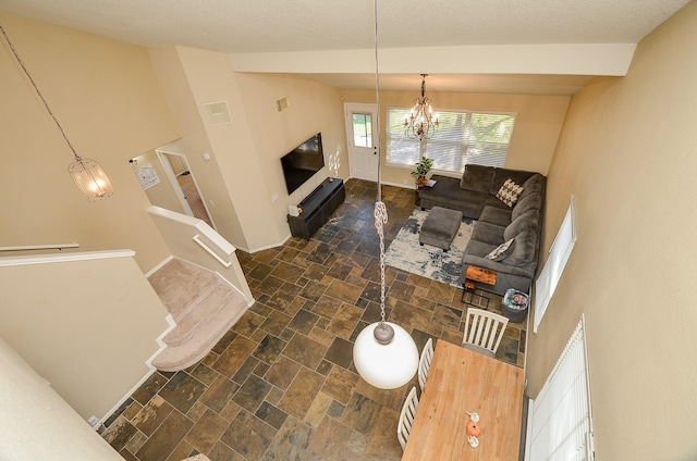 living room with a notable chandelier and vaulted ceiling