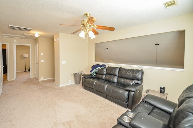 living room featuring a textured ceiling, ceiling fan, and light carpet