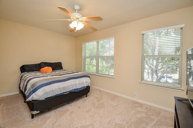 carpeted bedroom with multiple windows and ceiling fan