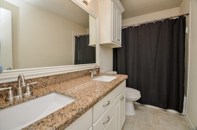 full bathroom featuring tile patterned floors, shower / tub combo with curtain, vanity, and toilet