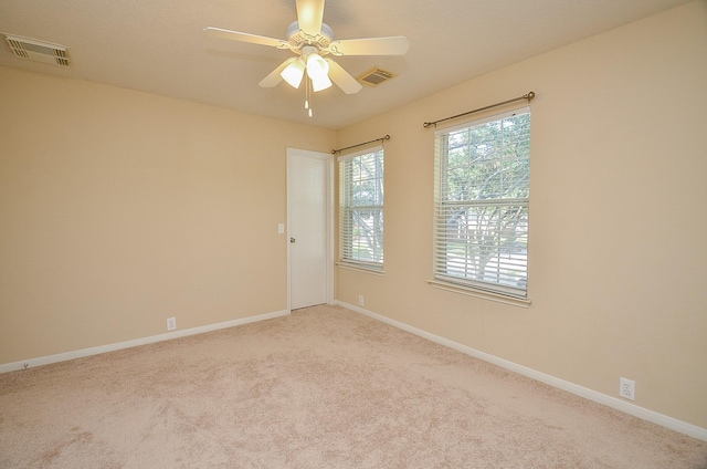 spare room featuring ceiling fan and light colored carpet