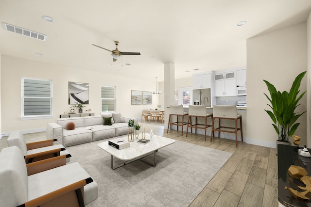 living room with light hardwood / wood-style floors and ceiling fan