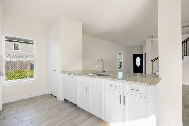 kitchen featuring dishwasher, light wood-type flooring, sink, and a wealth of natural light