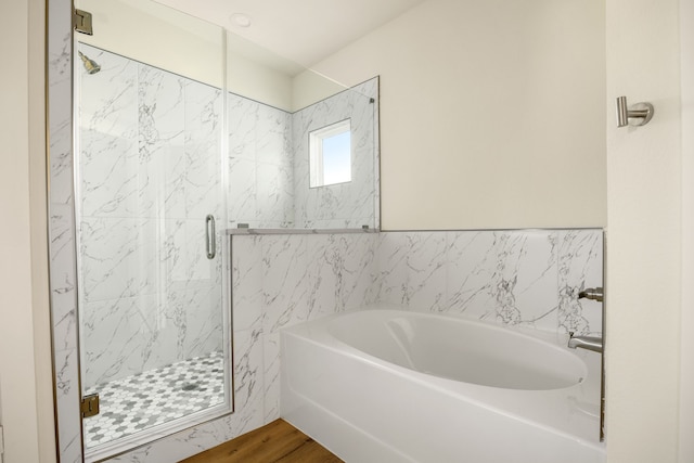 bathroom featuring wood-type flooring and shower with separate bathtub