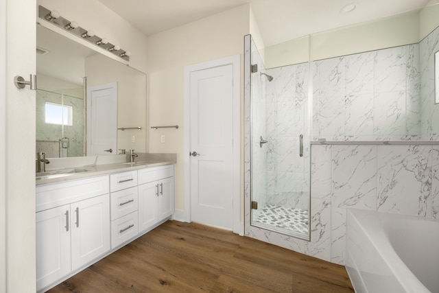 bathroom with hardwood / wood-style floors, vanity, and separate shower and tub