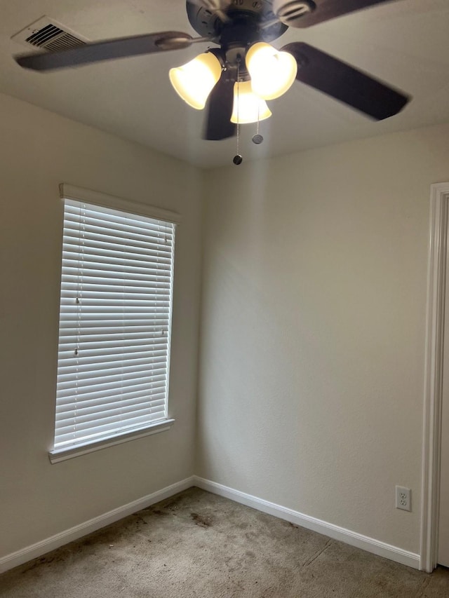 carpeted spare room with ceiling fan