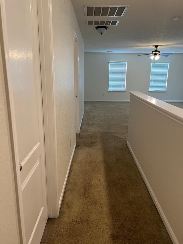 corridor with dark colored carpet