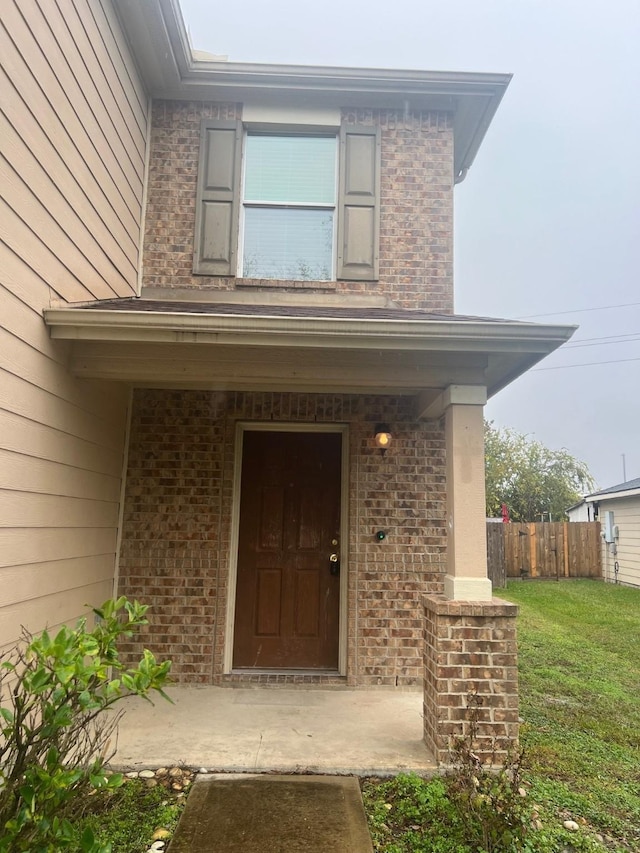 doorway to property with a lawn