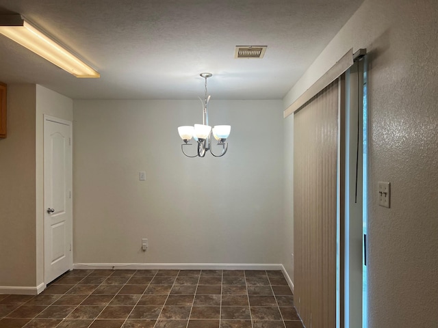 unfurnished room with an inviting chandelier