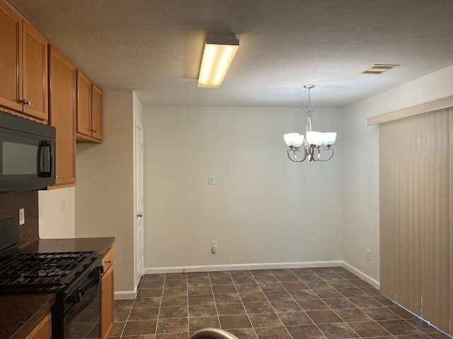 kitchen featuring black appliances, a notable chandelier, hanging light fixtures, and a textured ceiling