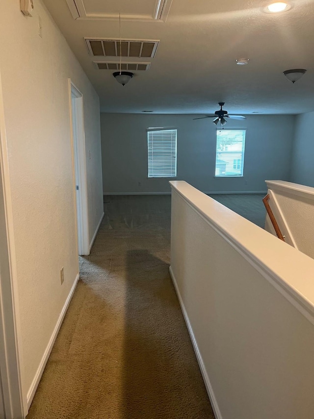 hall with dark colored carpet