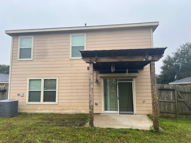 rear view of property featuring a lawn, central AC, and a patio