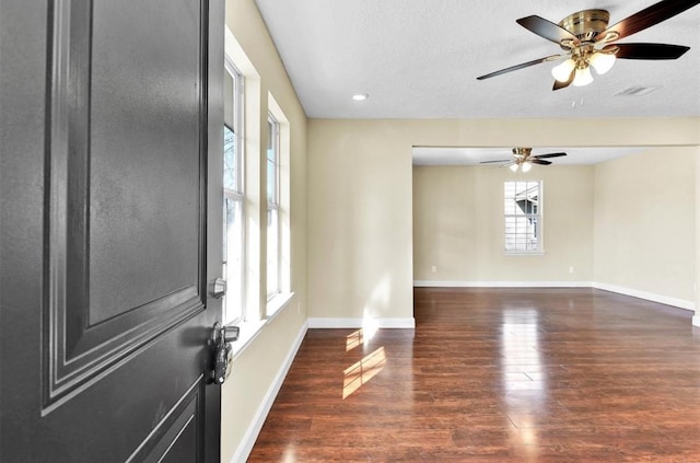 spare room with ceiling fan, dark hardwood / wood-style flooring, and a textured ceiling