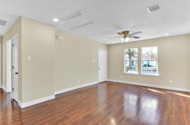 empty room featuring dark hardwood / wood-style floors, ceiling fan, and a textured ceiling