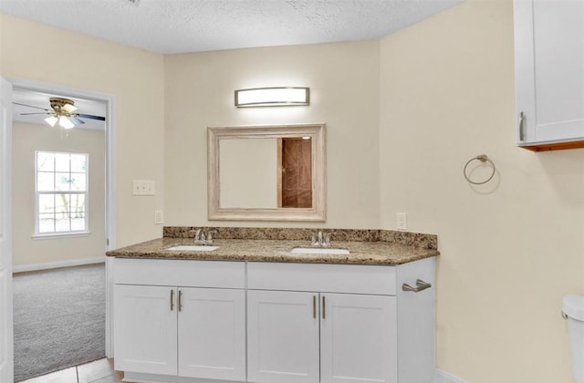 bathroom with vanity, tile patterned flooring, ceiling fan, toilet, and a textured ceiling