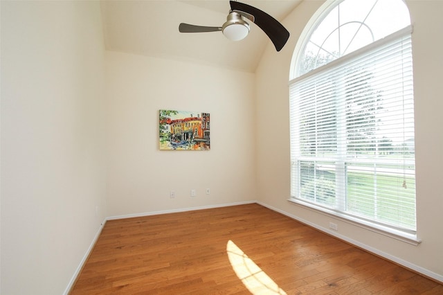 unfurnished room featuring hardwood / wood-style flooring, ceiling fan, lofted ceiling, and a wealth of natural light