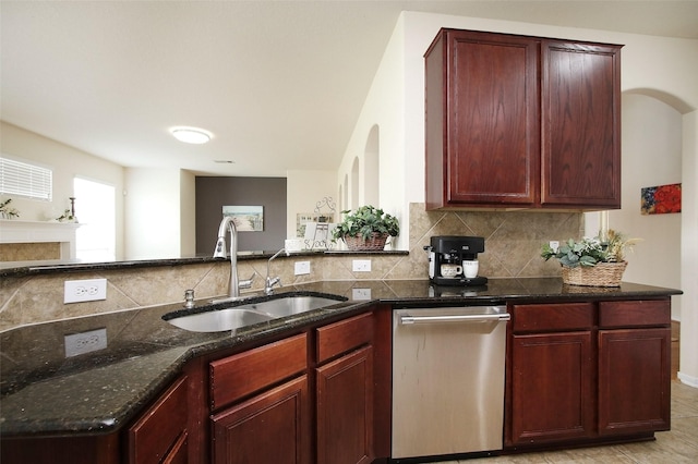 kitchen featuring dark stone counters, sink, stainless steel dishwasher, decorative backsplash, and light tile patterned floors