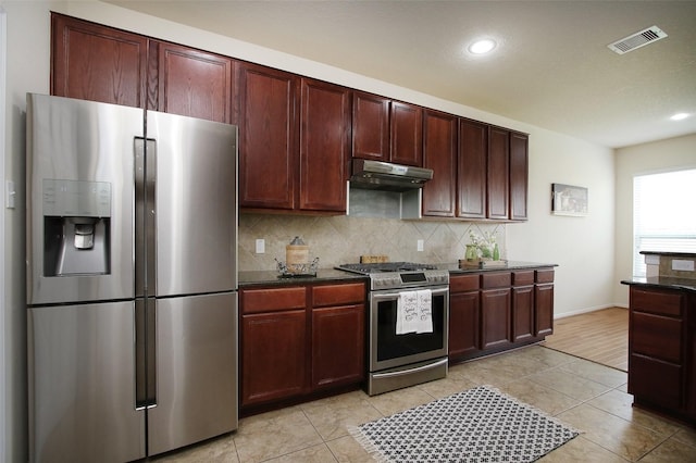 kitchen featuring light tile patterned floors, stainless steel appliances, and tasteful backsplash