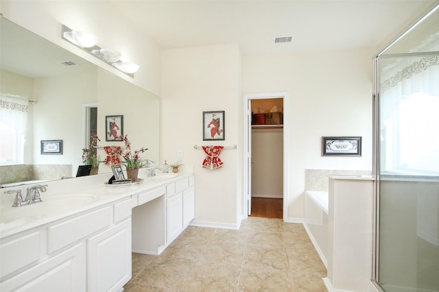 bathroom featuring tile patterned floors, plus walk in shower, and vanity