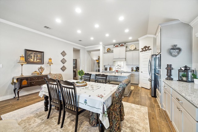 dining room featuring crown molding and wood-type flooring