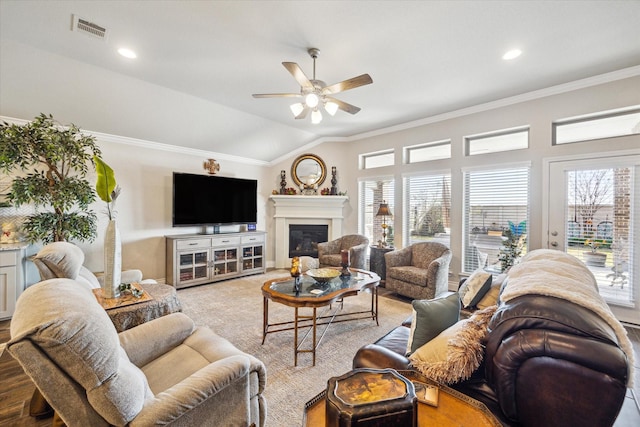 living room featuring ceiling fan, ornamental molding, and vaulted ceiling