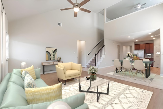 living room with light wood-type flooring, high vaulted ceiling, and ceiling fan