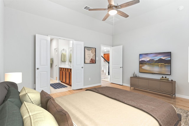 bedroom with ceiling fan, light wood-type flooring, and ensuite bath