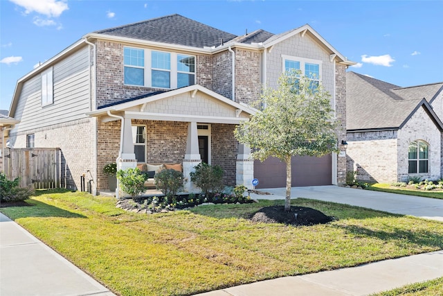 view of front of property with covered porch, a garage, and a front lawn