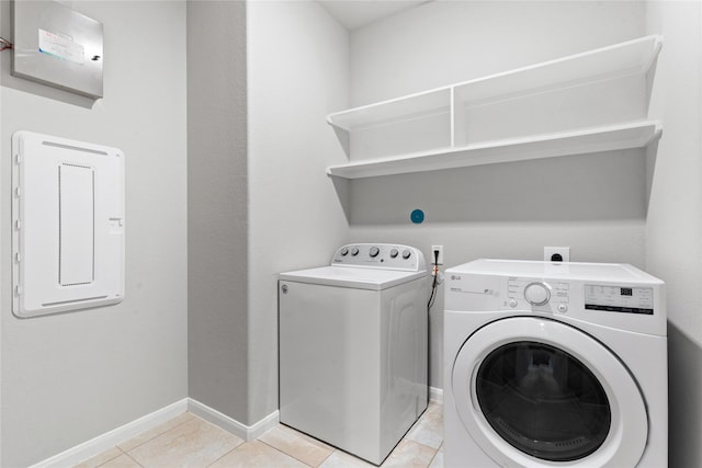 laundry area with electric panel, light tile patterned floors, and independent washer and dryer