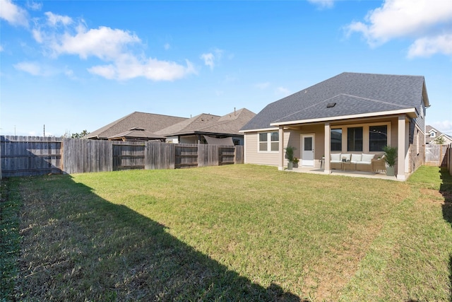 back of property featuring an outdoor living space, a patio area, and a yard