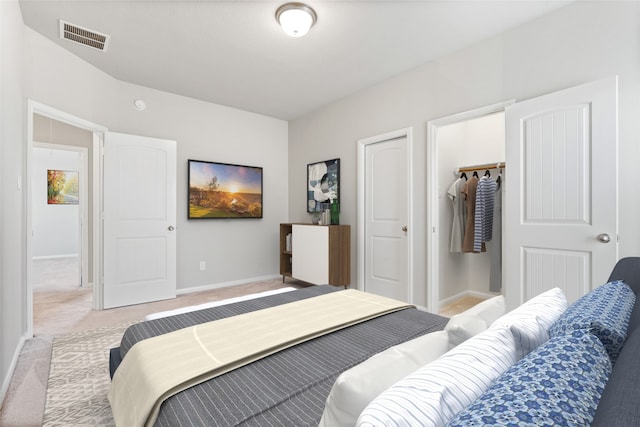 carpeted bedroom featuring a spacious closet and a closet