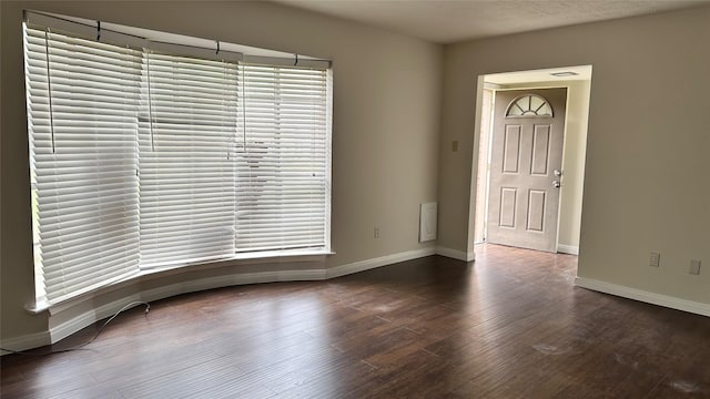 unfurnished room with dark hardwood / wood-style flooring