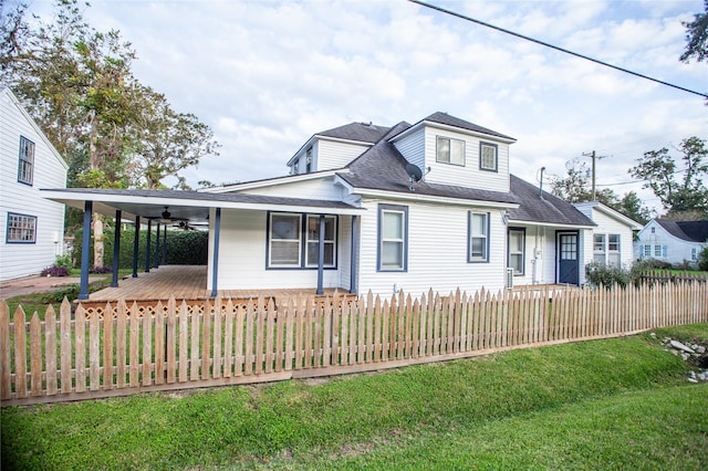 view of front facade with ceiling fan, covered porch, and a front lawn