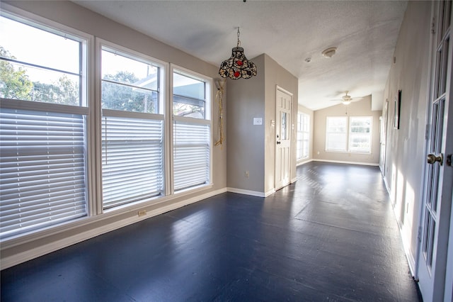 interior space with ceiling fan, a healthy amount of sunlight, vaulted ceiling, and a textured ceiling