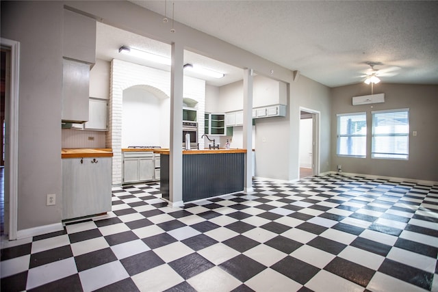 kitchen featuring white cabinetry, butcher block counters, and tasteful backsplash