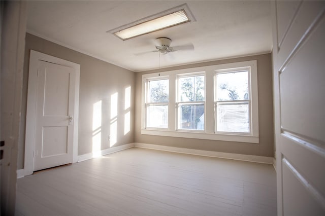 empty room with ceiling fan, ornamental molding, and light hardwood / wood-style flooring