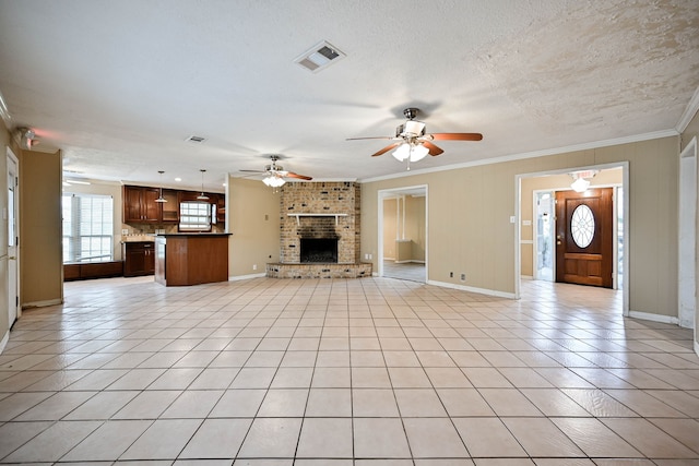 unfurnished living room with a textured ceiling, light tile patterned flooring, crown molding, and a brick fireplace