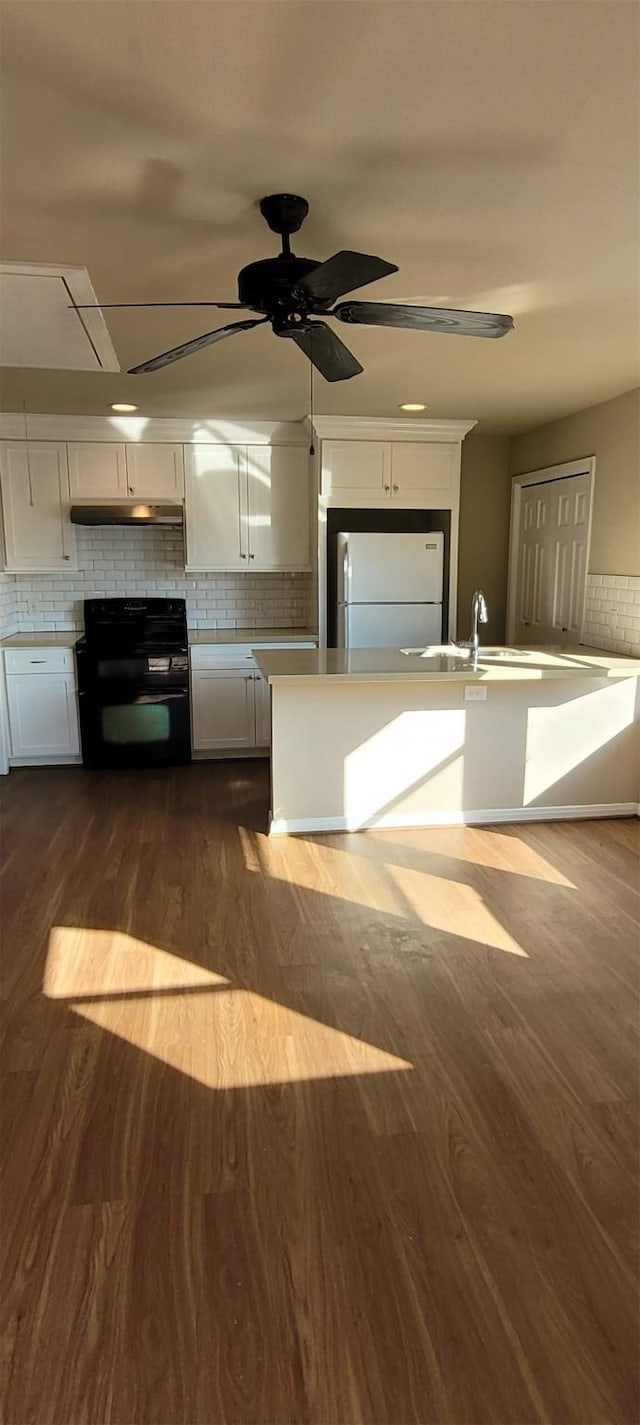 kitchen featuring white cabinetry, black electric range, dark hardwood / wood-style floors, backsplash, and white fridge