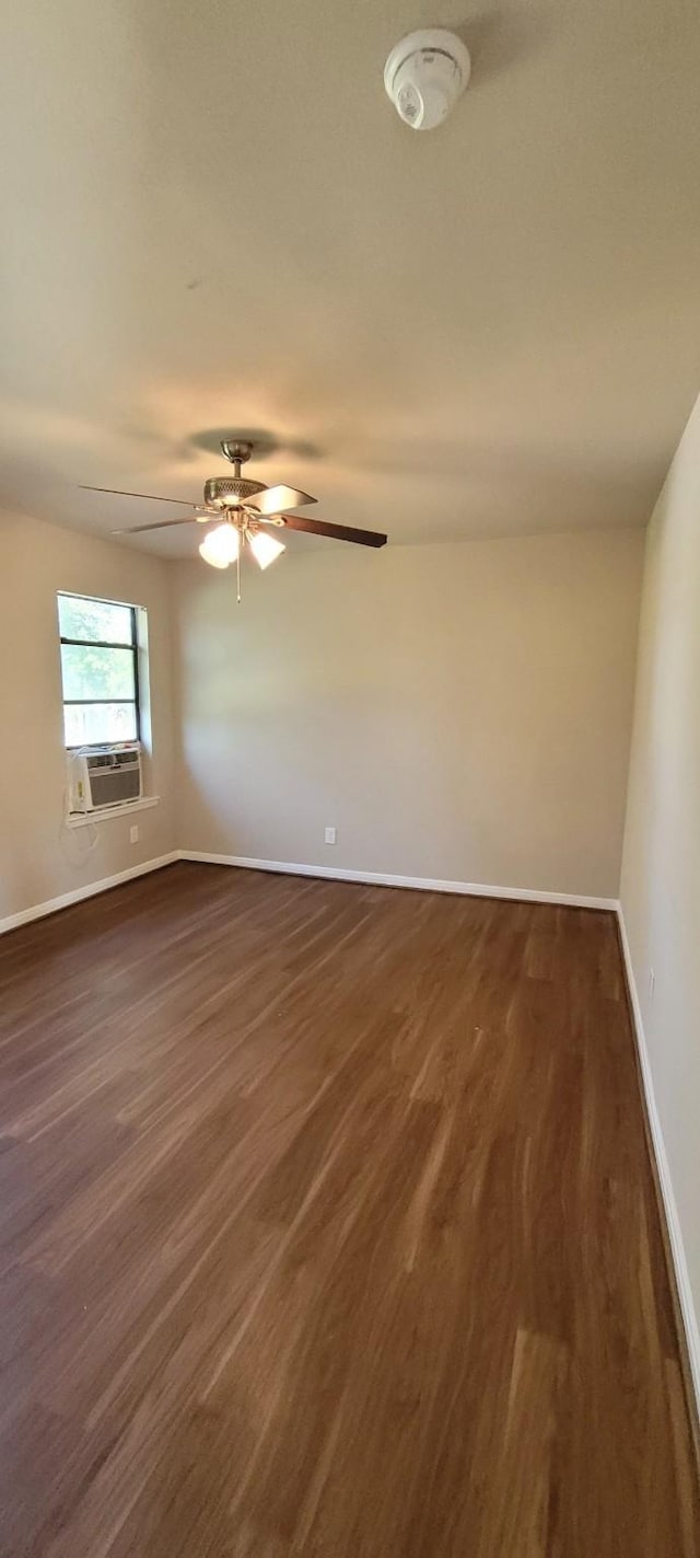 empty room with dark hardwood / wood-style flooring, cooling unit, and ceiling fan