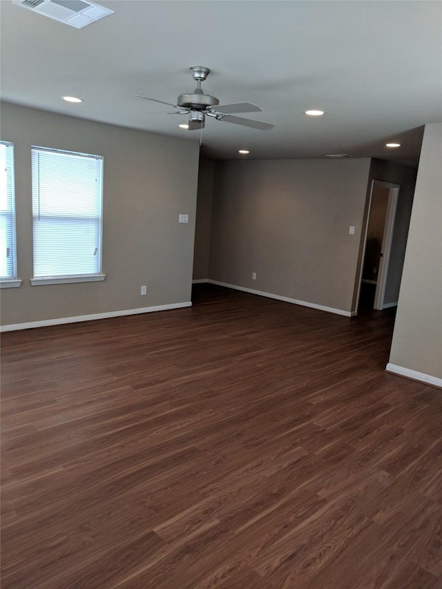 empty room with ceiling fan and dark wood-type flooring