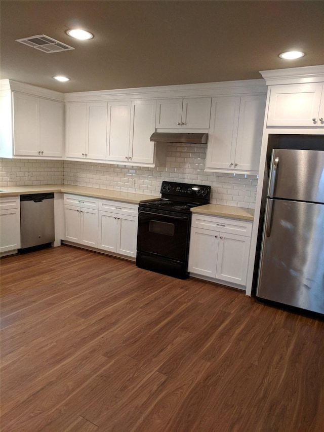 kitchen with white cabinets, appliances with stainless steel finishes, backsplash, and dark hardwood / wood-style floors