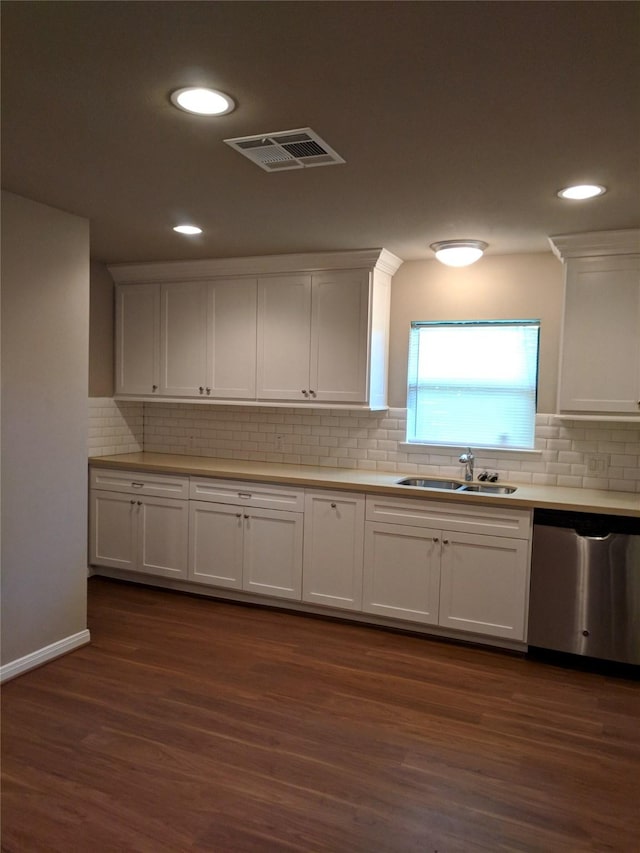 kitchen featuring white cabinetry, sink, stainless steel dishwasher, dark hardwood / wood-style floors, and decorative backsplash